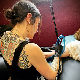 sheila.tattoos expertly tattoos a custom blackwork design on a clients arm in Santa Cruz CA